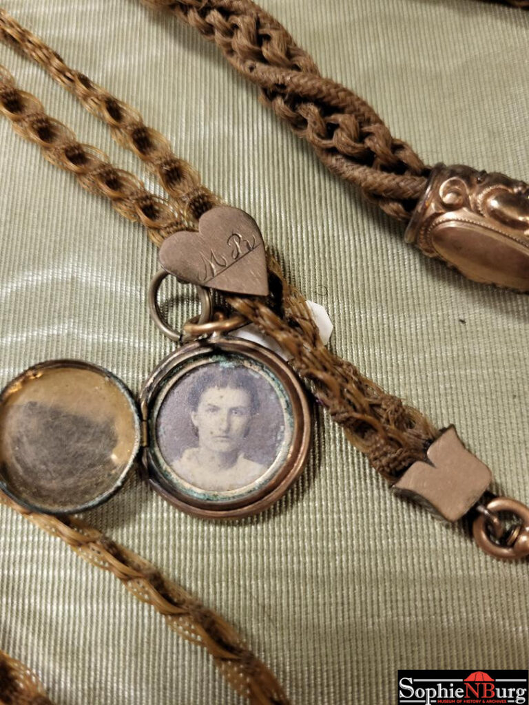 Photo caption: Detail of locket on watch chain made of hair in the 1870s. (Sophienburg artifact collection)