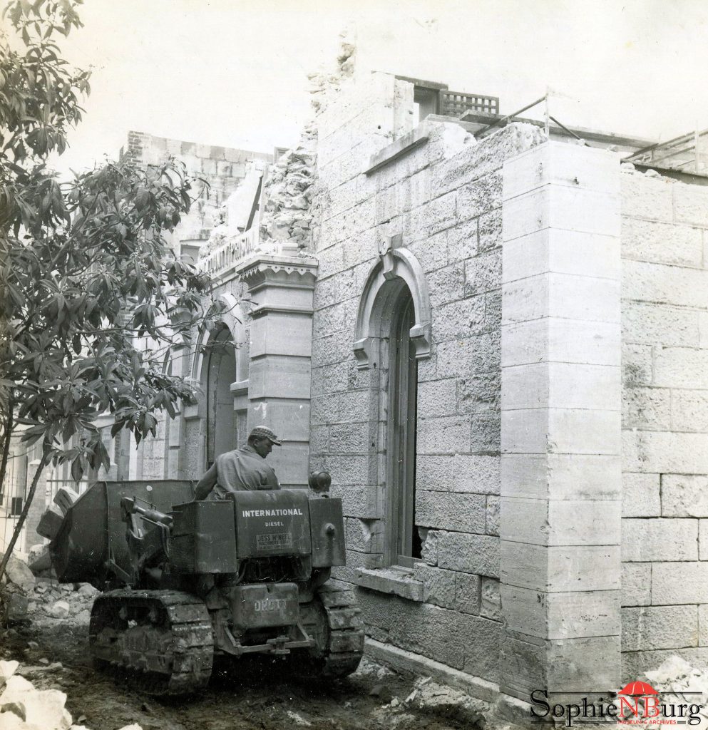 Photo Caption: 1878 Comal County Jail building when it was being bulldozed to make additions to the Texas Commerce, now Chase, bank building. Note the iron cell door on the second floor.
