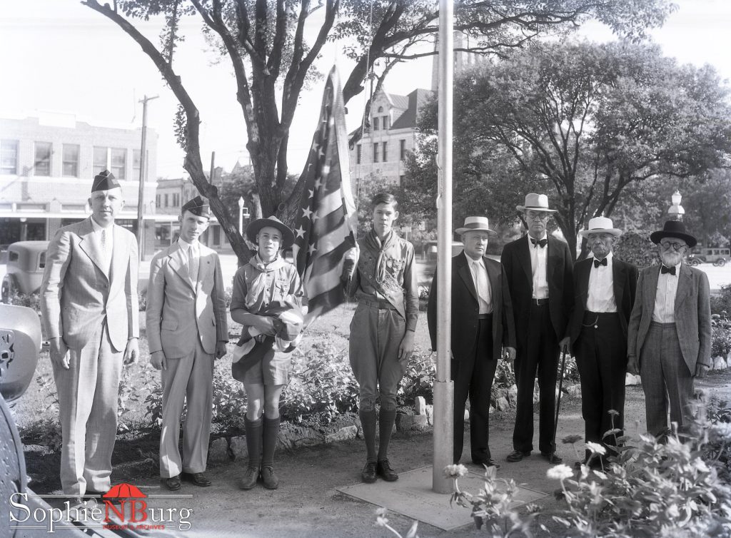 Photo Caption: American Legion, Boy Scouts and Veterans raising US flag on Main Plaza in New Braunfels, June 6, 1933.
